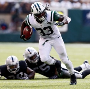 Chris Ivory #33 of the New York Jets rushes after evading tackle attempts by T.J. Carrie #38 and Sio Moore #55 of the Oakland Raiders during the third quarter of a game at MetLife Stadium on September 7, 2014 in East Rutherford, New Jersey. (Photo by Jeff Zelevansky/Getty Images)
