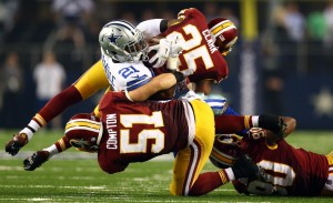 ARLINGTON, TX - OCTOBER 27: Joseph Randle #21 of the Dallas Cowboys is tackled by Everette Brown #51 and Ryan Clark #25 of the Washington Redskins during the second half at AT&T Stadium on October 27, 2014 in Arlington, Texas. (Photo by Ronald Martinez/Getty Images)